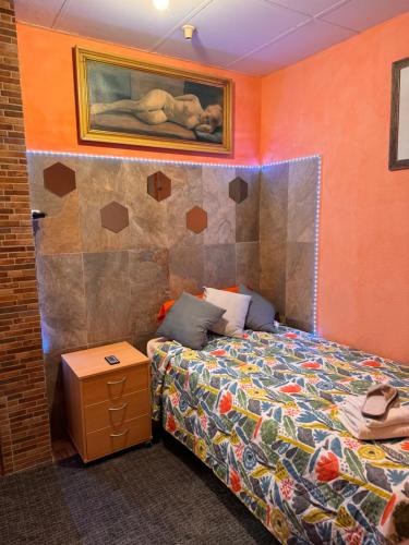 Bonita habitación en chalet في برشلونة: غرفة نوم بسرير ودهان على الحائط