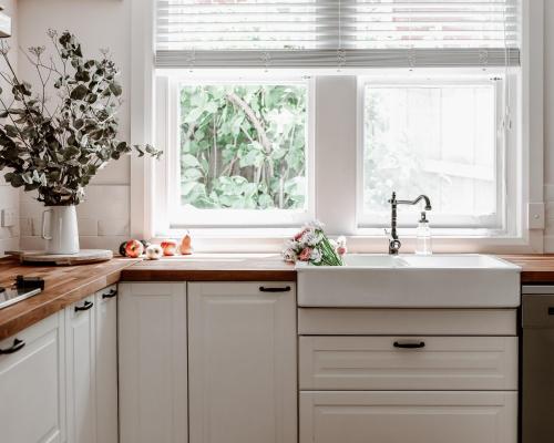eine weiße Küche mit einem Waschbecken und einem Fenster in der Unterkunft Gatekeepers Lodge - A Historic Hobart Experience in Hobart