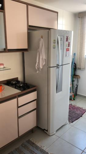 een keuken met een koelkast en een fornuis bij Apartamento encantandor-perto centro e shopping in Poços de Caldas