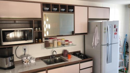a kitchen with a white refrigerator and a sink at Apartamento encantandor-perto centro e shopping in Poços de Caldas