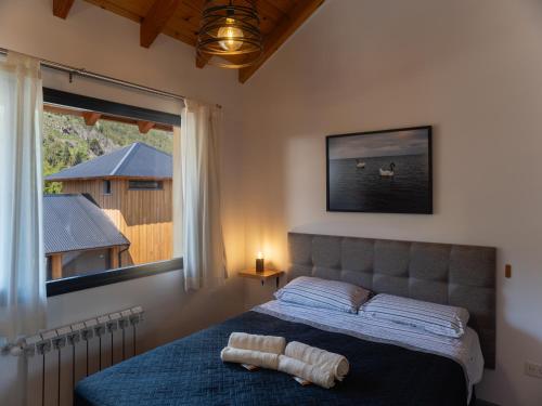 Schlafzimmer mit einem Bett und einem großen Fenster in der Unterkunft Loretta IV in San Martín de los Andes
