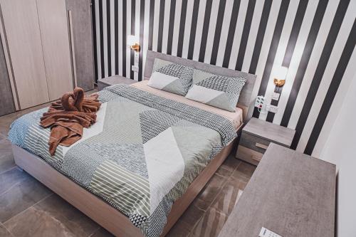 a bedroom with a bed with a striped wall at Brand new apartment close to Valletta in Tal-Pietà