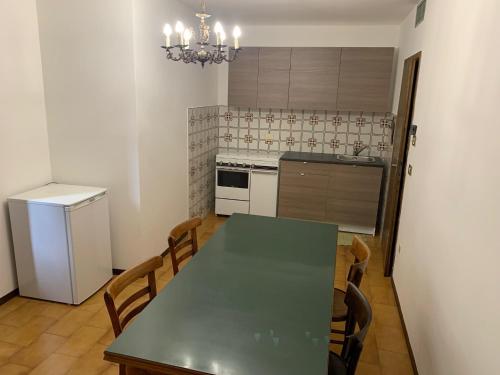 cocina con mesa, sillas y nevera en Appartamento a Bagolino (BS) en Bagolino