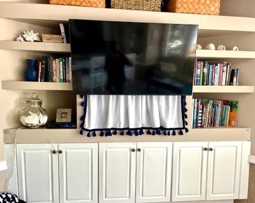 uma televisão de ecrã plano em cima de uma estante de livros em Sarasota Bay em Bradenton