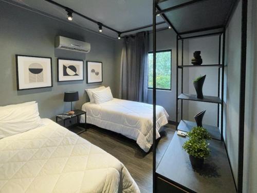 1 dormitorio con 2 camas y espejo en Mighil Hotel & Eventos, en Florianópolis