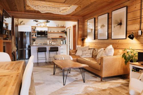 een woonkamer met een bank en een tafel bij The Kootenay Lake House - A Private Luxury Retreat in Nakusp