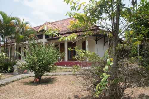 a house with a garden in front of it at Guesthouse Rumah Senang in Kalibaru