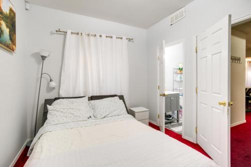 a bedroom with a white bed and a red carpet at Convenient Denver Apartment about 10 Mi to Downtown! in Aurora
