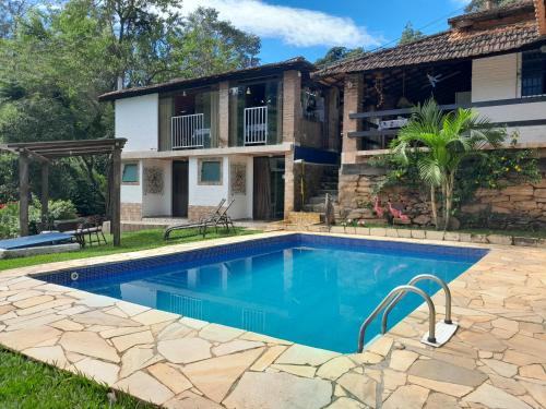 an image of a swimming pool in front of a house at Pousada Estância Vip in Cunha