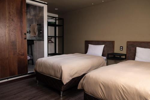 Habitación de hotel con 2 camas y ventana en BB&B Hostel en La Paz