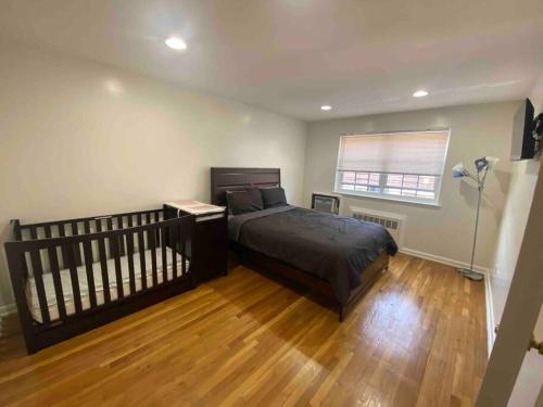 a bedroom with a bed and a wooden floor at Cozy 2-bedrooms bungalow in Canarsie Brooklyn in Brooklyn