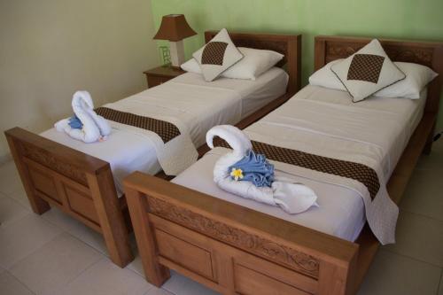 two beds with towels on them in a room at Guesthouse Rumah Senang in Kalibaru
