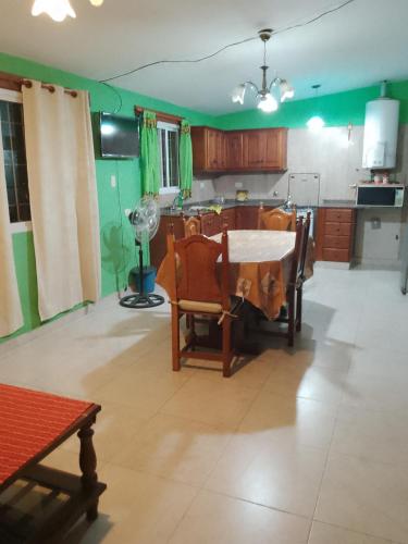 een keuken met een tafel en stoelen en groene muren bij Felipe Chalet in La Falda