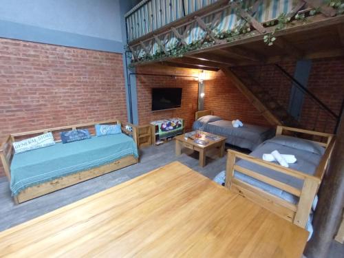 ein Wohnzimmer mit einem Bett und einem Sofa in der Unterkunft Escala Ezeiza Loft con desayuno in Luis Guillón