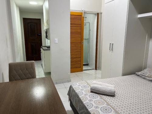 1 dormitorio con cama, mesa y baño en Apartamento na Praia de Botafogo todo reformado, en Río de Janeiro