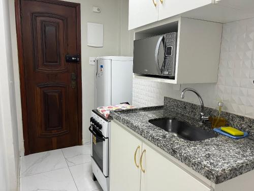 La cuisine est équipée d'un évier et d'un four micro-ondes. dans l'établissement Apartamento na Praia de Botafogo todo reformado, à Rio de Janeiro