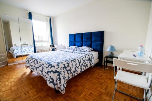 - une chambre avec un lit doté d'une tête de lit bleue et d'un lavabo dans l'établissement hyper centre carouge QDC, à Genève