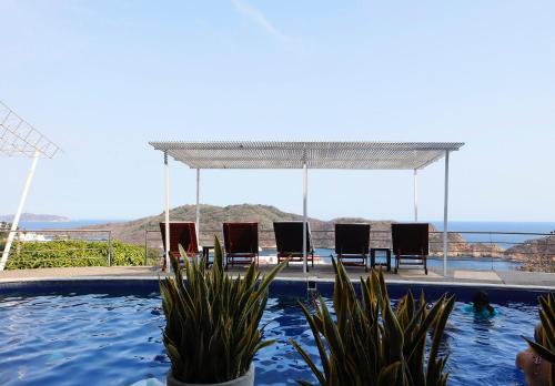 um grupo de cadeiras sentadas numa piscina em Casas del Acantilado - Acapulco em Acapulco