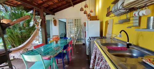 a kitchen with a sink and a table with chairs at Recanto da Poesia in Campo Grande