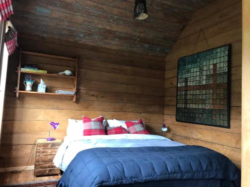 a bedroom with a bed in a wooden wall at Kanuka Retreat in Akaroa