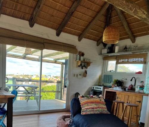 een woonkamer met een blauwe bank en een keuken bij Palapa Suite in Punta Del Diablo