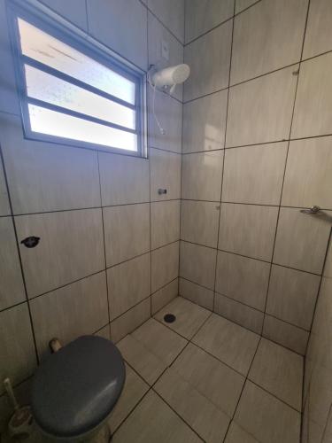 a bathroom with a shower with a toilet and a window at Pousada Renascer in Cuiabá