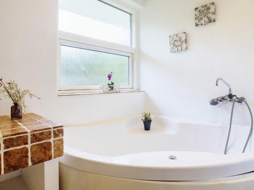 a white bath tub in a bathroom with a window at 10 person holiday home in V ggerl se in Marielyst