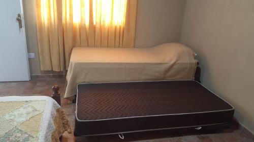 a room with two beds and a suitcase on the floor at Alquiler temporario Natal, en la entrada a Posadas in Garupá