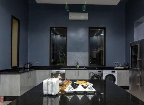 Palatial Oasis with Pool- VacayX - MARRAKECH في مراكش: مطبخ كبير مع غسالة ملابس وطاولة عليها حذاء