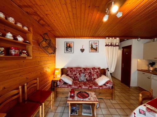 - un salon avec un canapé dans une pièce en bois dans l'établissement Appartement avec Terrasse & Piscine Privée, Gérardmer - FR-1-589-56, à Gérardmer
