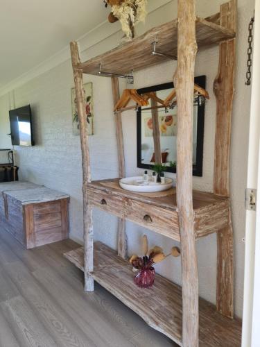 a bathroom with a wooden shelf with a sink at Vacy Hunter Valley Lodge in Vacy