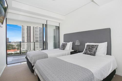 2 camas en una habitación de hotel con ventana grande en A Perfect Stay - Sierra Grande, en Gold Coast