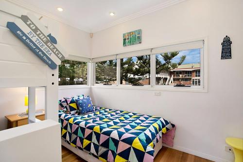 a bedroom with a bed and a window at Tobys Beach House in Gold Coast