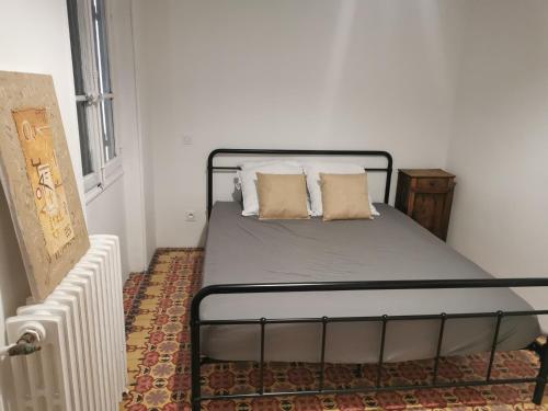 un lit avec deux oreillers dessus dans une chambre dans l'établissement Magnifique maison années 30 proche des remparts, à Avignon