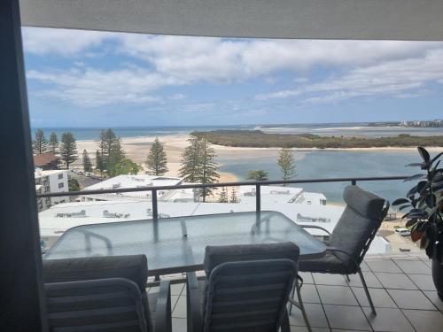 a table and chairs on a balcony with a view of the beach at The Waterford Prestige Apartments in Caloundra