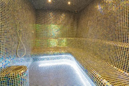 a tiled shower with a tub in a bathroom at Hotel Slávia Svidník SPA & RESTAURANT in Svidník