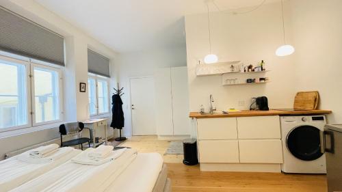 cocina con armarios blancos, fregadero y fogones en ApartmentInCopenhagen Apartment 1539, en Copenhague