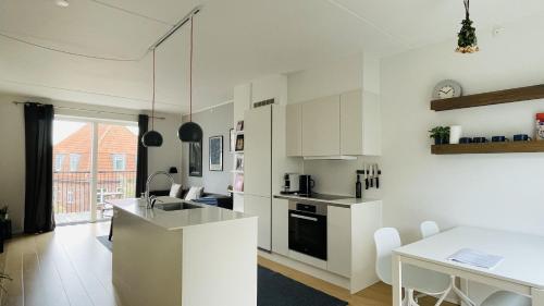a kitchen with white cabinets and a white table at ApartmentInCopenhagen Apartment 1561 in Copenhagen
