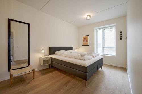 een slaapkamer met een groot bed en een grote spiegel bij ApartmentInCopenhagen Apartment 1559 in Kopenhagen