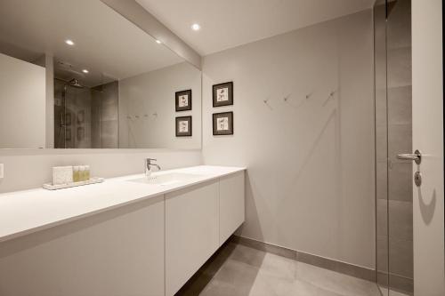 een witte badkamer met een wastafel en een douche bij ApartmentInCopenhagen Apartment 1559 in Kopenhagen