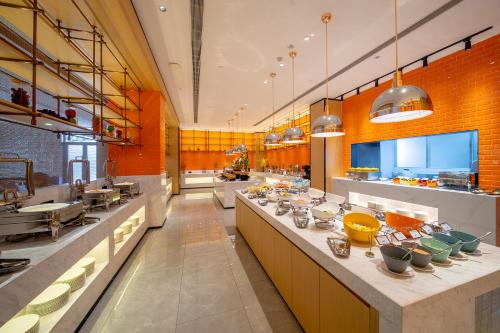 a large kitchen with a long counter with bowls on it at Guangzhou Baiyun Airport Rezen Select Hotel in Huadu