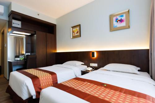 a hotel room with two beds and a bathroom at 56 Hotel in Kuching