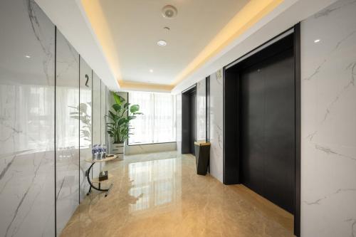 a hallway with a black door in a building at 广州白云国际机场可可Coco酒店-广交会期间展馆穿梭巴士 in Huadu