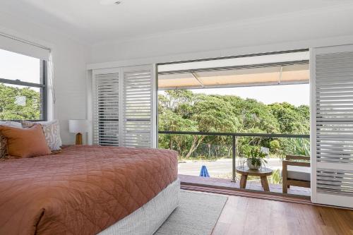 1 dormitorio con cama y ventana grande en A Perfect Stay - 1 James Cook Apartments, en Byron Bay