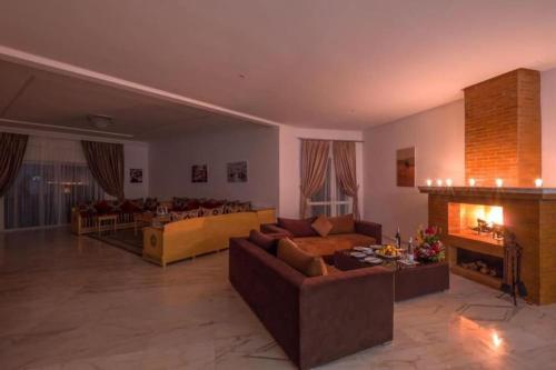 a large living room with couches and a fireplace at Luxe Oasis - VacayX - MARRAKECH in Marrakech