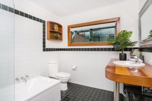 a bathroom with a sink and a toilet and a tub at A Perfect Stay - 3 Little Pigs in Byron Bay