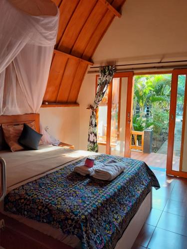 um quarto com uma cama num quarto com janelas em Florine's Garden em Gili Air
