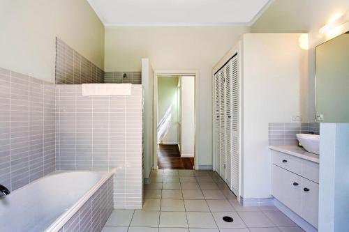 a bathroom with a tub and a sink at A Perfect Stay - A Summer Cottage in Byron Bay
