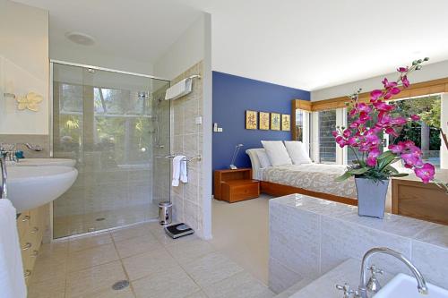 a bathroom with a bed and a shower and a sink at A Perfect Stay - Abode at Byron in Ewingsdale