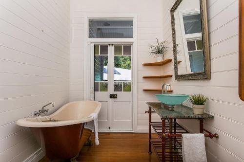 a bathroom with a tub and a sink and a mirror at A Perfect Stay - Bangalla in Coorabell Creek